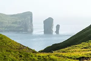 Dramatic view on Drangarnir and Tindholmur sea stacks in Atlantic ocean from Vagar island, Faroe Islands. Landscape photography