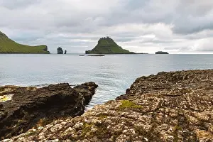 Dramatic view on Drangarnir and Tindholmur sea stacks in Atlantic ocean from Vagar island, Faroe Islands. Landscape photography