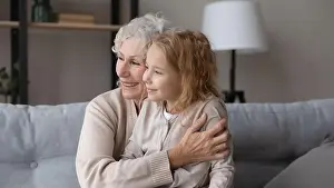 Knees Prints: Dreamy little girl sit on knees of loving elderly grandmother