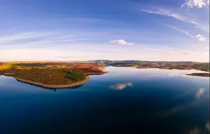 Water Reservoir Prints: Drone aerial view of a lake reservoir of a dam with perfect reflection on the water of the sky in Sabugal