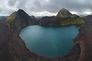 Stark Prints: Drone capture of a striking turquoise lake nestled within multiple volcanic mounts in the Icelandic highlands