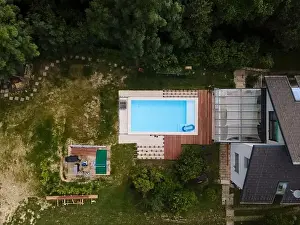 Hydro Massage Prints: Drone flight over beautiful green garden with pool and the wooden terrace of the pool is currently in progress