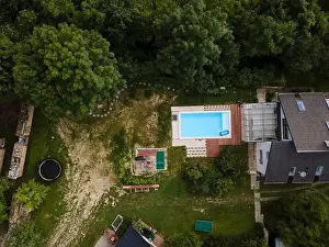 Hydro Massage Prints: Drone flight over beautiful green garden with pool and the wooden terrace of the pool is currently in progress