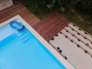 Above View Prints: Drone flight over beautiful green garden with pool and the wooden terrace of the pool is currently in progress