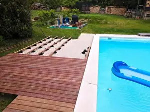 Above View Prints: Drone flight over beautiful green garden with pool and the wooden terrace of the pool is currently in progress