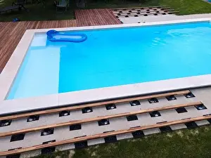 Above View Prints: Drone flight over beautiful green garden with pool and the wooden terrace of the pool is currently in progress