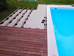 Above View Prints: Drone flight over beautiful green garden with pool and the wooden terrace of the pool is currently in progress