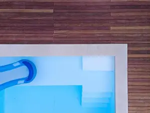 Above View Prints: Drone flight over beautiful green garden with pool and the wooden terrace of the pool is currently in progress