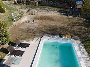 Drone flight over fresh earth area with grass grown next to pool construction site in April