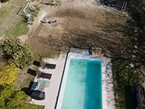 Drone flight over fresh earth area with grass grown next to pool construction site in April