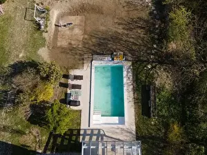 Drone flight over fresh earth area with grass grown next to pool construction site in April