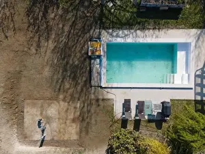Drone flight over fresh earth area with grass grown next to pool construction site in April