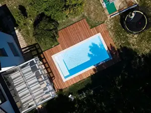 Above View Prints: Drone flight over pool with nice wooden terrace surrounded by green lawn in beautiful garden