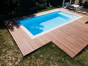 Above View Prints: Drone flight over pool with nice wooden terrace surrounded by green lawn in beautiful garden