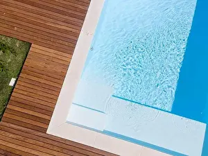 Above View Prints: Drone flight over pool with nice wooden terrace surrounded by green lawn in beautiful garden