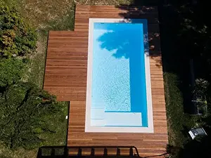 Above View Prints: Drone flight over pool with nice wooden terrace surrounded by green lawn in beautiful garden