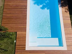 Above View Prints: Drone flight over pool with nice wooden terrace surrounded by green lawn in beautiful garden