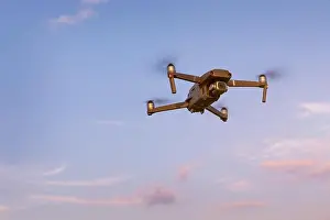 Hovering Prints: Drone flying over landscape. UAV drone copter flying with digital camera