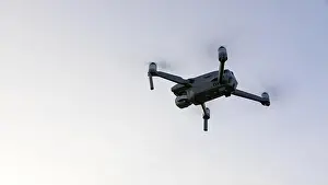 Hovering Prints: Drone flying over landscape. UAV drone copter flying with digital camera