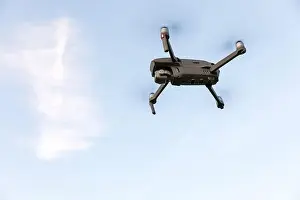 Hovering Prints: Drone flying over landscape. UAV drone copter flying with digital camera