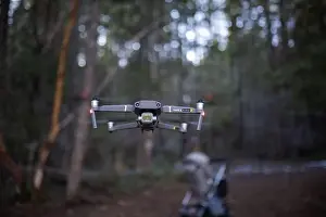 Drone flying low in the middle of a forest