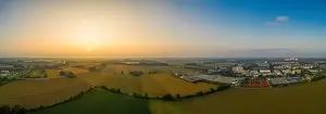 Awakening Prints: Drone footage - sunrise view over fields and a nearby situated business district