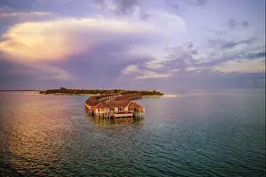 Drone photo wooden water villas seen from above and an amazing blue lagoon crystal clear water close to tropical lagoon. Amazing summer