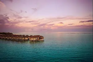 Drone photo wooden water villas seen from above and an amazing blue lagoon crystal clear water close to tropical lagoon. Amazing summer