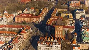 A drone shot captures Koszalin city center bathed in golden light