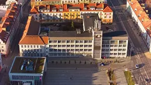 A drone shot captures Koszalin city center bathed in golden light