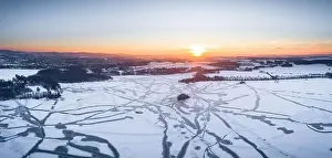 Drone shot above the Dam reservoir in Bautzen during sunset with frozen lake winter season ice snow white