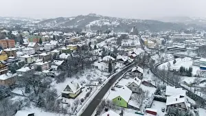 Drone shot of a small town named Limanowa in mountains in Poland covered with fog and snow