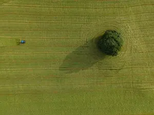 Mowing Prints: A drone shot of a tractor turning grass in a meadow near the Yorkshire Dales village of Malham