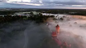 Scape Prints: drone shot of turaida castle in early morning with fog in the forest valley