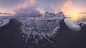Vestrahorn Prints: Drone view of calm frozen endless sea surrounding high rocky snowy Vestrahorn mountain during picturesque sunset