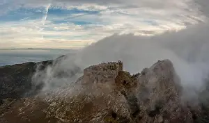 Castello Prints: Drone view of the Castello del Volterraio shrouded in morning fog and cloud