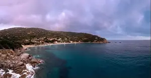 A drone view of Cavoli Beach on Elba Island just after sunset with a misty purple sky