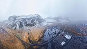 Freeway Prints: Drone view of curvy asphalt road going through frozen lake in winter time in Iceland