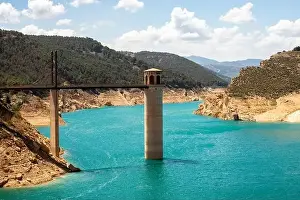 Drone view of Francisco Abellán Reservoir bridge above blue water on sunny day located in La Peza in Spain