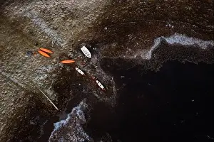 Located Prints: Drone view of kayaks located on frozen shore of pond in winter in Scottish Highlands