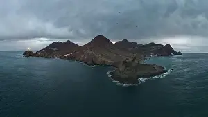 Navigate Prints: Drone view of lighthouse located on rough cliff near sea under cloudy sky in Almeria