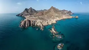 Navigate Prints: Drone view of lighthouse located on rough cliff near sea under cloudy sky in Almeria