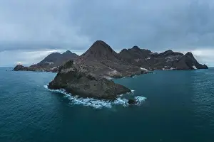 Navigate Prints: Drone view of lighthouse located on rough cliff near sea under cloudy sky in Almeria