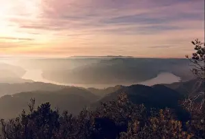 Drone view of picturesque scenery with bright sunset sky over foggy mountains and hills in Almatret