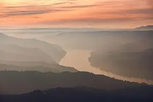 Drone view of picturesque scenery with bright sunset sky over foggy river and hills in Almatret
