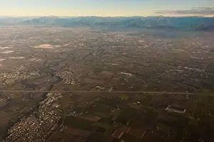 Northeastern Prints: Drone view of rough mounts against building roofs between roadways at sunrise in Dolomites Italy