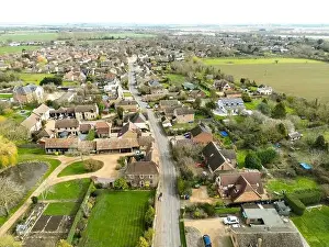 Solar Panels Prints: Drone view of a sprawling East Anglian village showing the main roadway leading through the bottom of the image