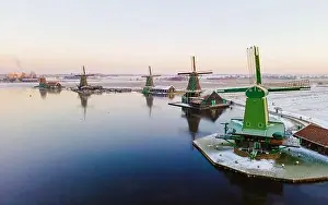 Drone view at the Zaanse Schans windmill village during winter with snow in the Netherlands
