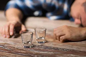 Asleep Prints: drunk man with empty glasses on table at night