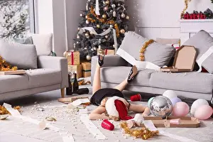 Hangover Prints: Drunk young woman lying on floor in messy living room after New Year party